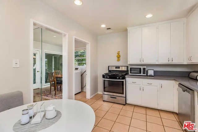 a kitchen with granite countertop a sink stove and cabinets