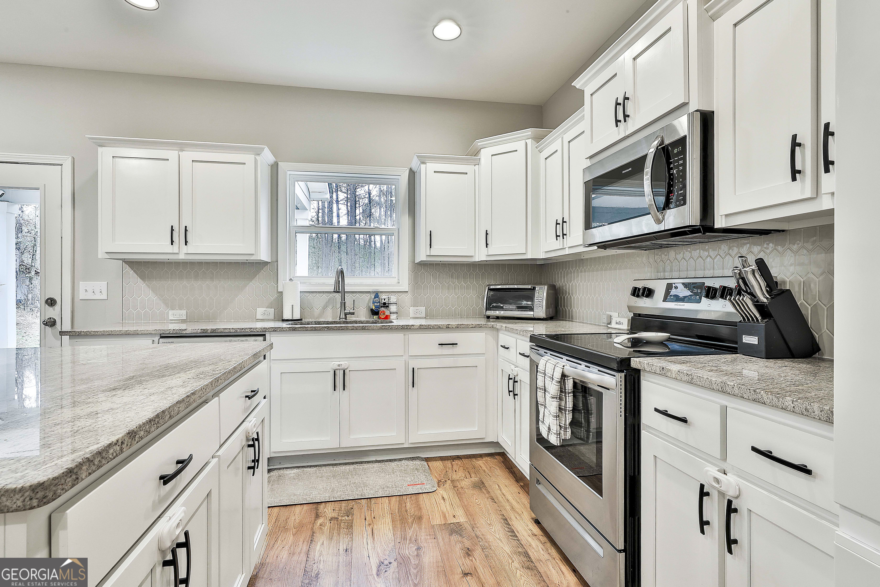 250 Mobley Bridge Road LaGrange, GA 30241 - Photo 18 of 42 a kitchen with stainless steel appliances granite countertop white cabinets granite counter tops and a hard wood floors