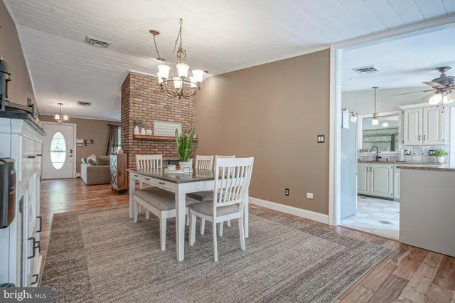 a view of a dining room with furniture a chandelier and wooden floor