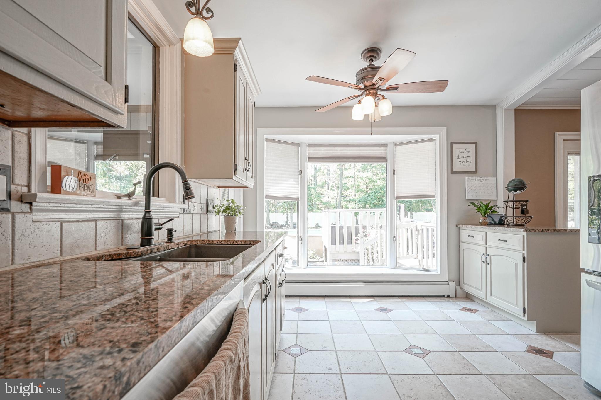 750 Moss Mill Road Hammonton, NJ 08037 - Photo 17 of 57 a kitchen with granite countertop a sink appliances cabinets and a large window