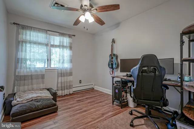 a view of room with workspace and wooden floor
