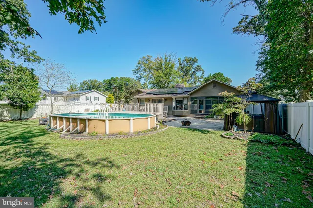 an aerial view of a house with swimming pool a yard and a large tree