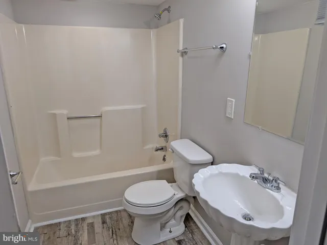 a white toilet sitting next to a bath tub