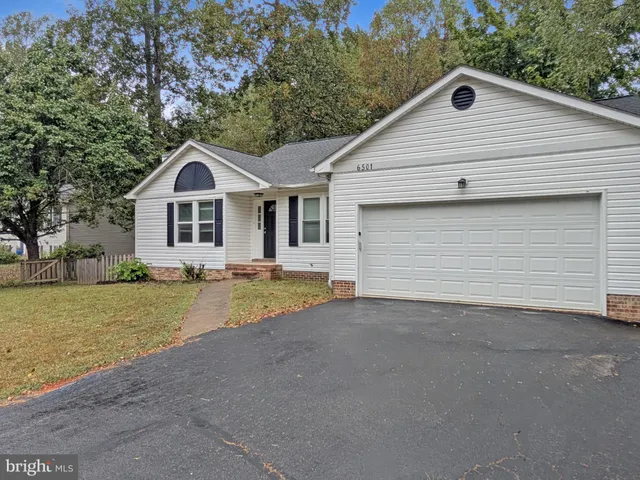 a view of a house with a yard and large tree