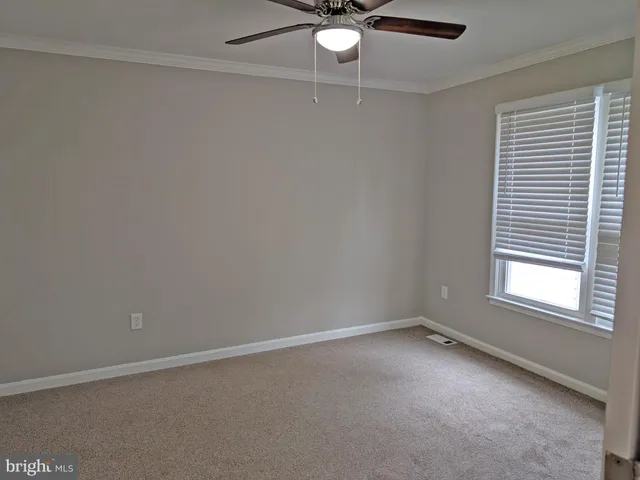 an empty room with a window and a fan