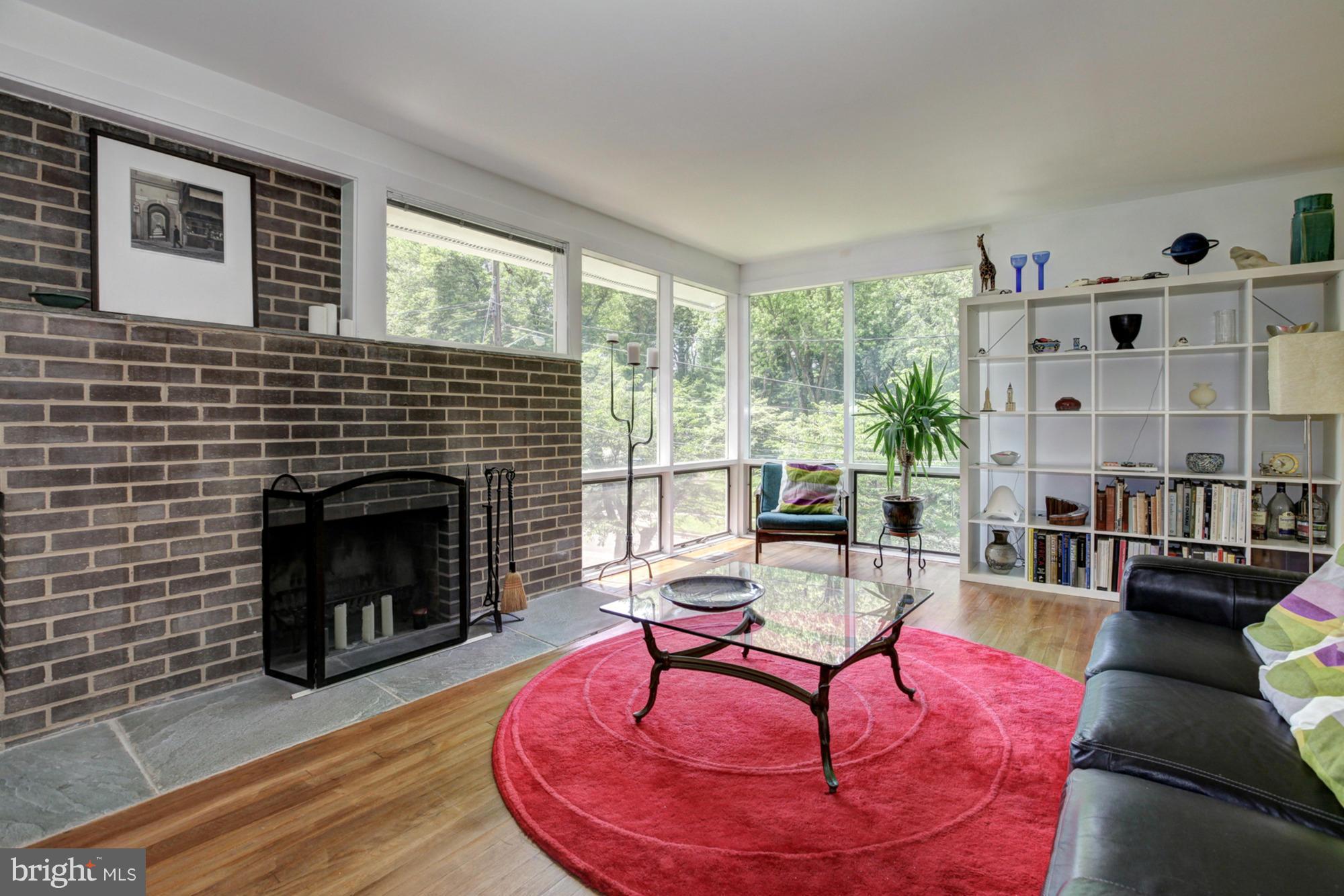 3946 Rickover Road Silver Spring, MD 20902 - Photo 13 of 30 a living room with furniture a fireplace and a floor to ceiling window