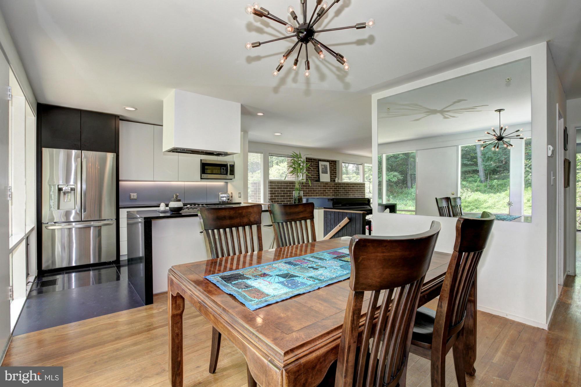 3946 Rickover Road Silver Spring, MD 20902 - Photo 10 of 30 a kitchen with stainless steel appliances granite countertop a stove a refrigerator a kitchen island a sink dishwasher and a dining table with wooden floor