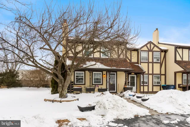 a front view of a house with a yard covered in snow