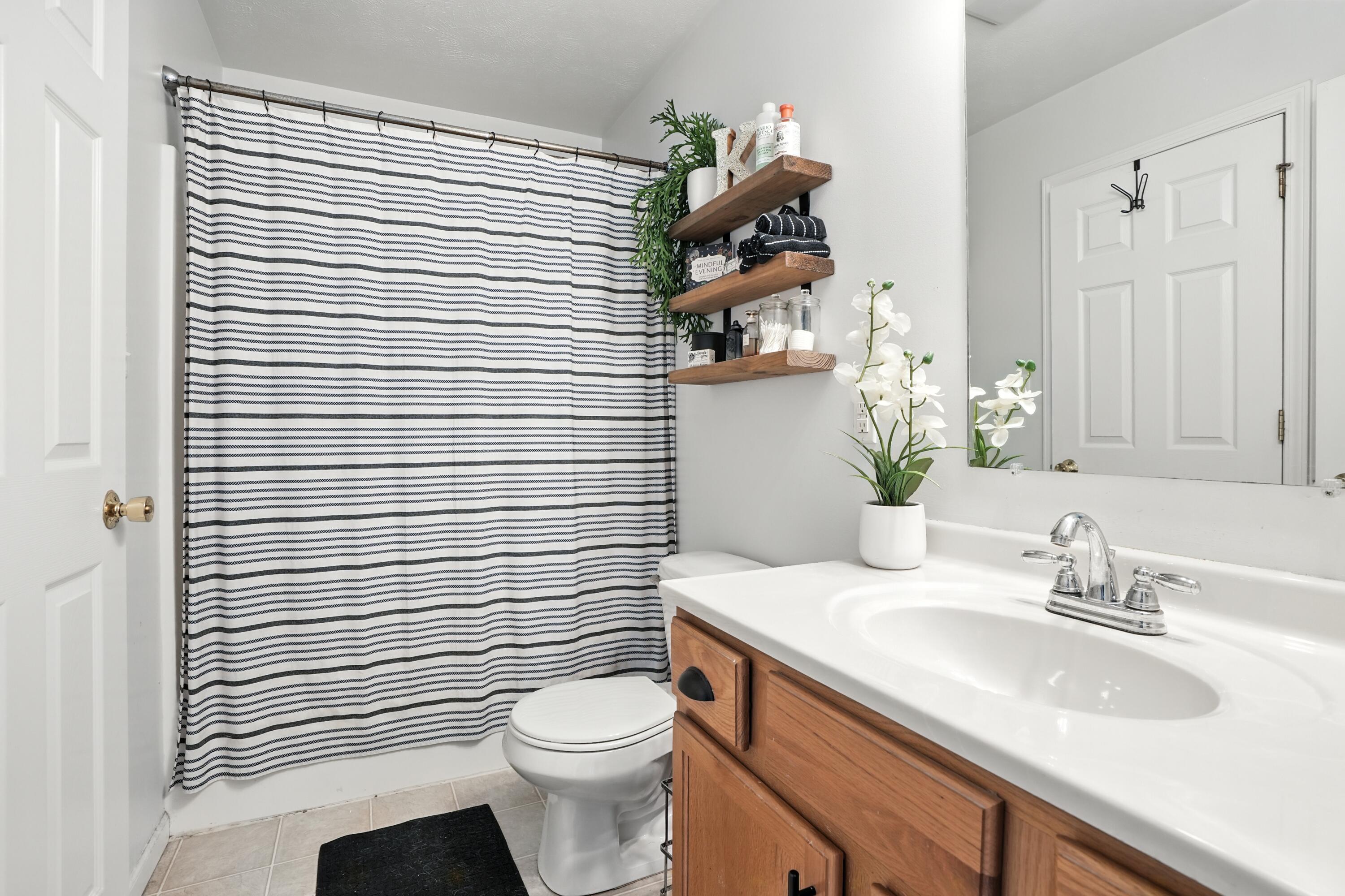 922 East 115th Place Crown Point, IN 46307 - Photo 15 of 23 a bathroom with a toilet a sink and mirror