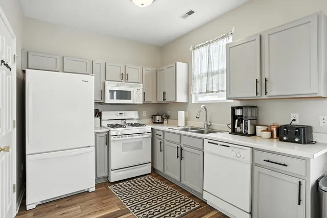 a kitchen with white cabinets and white appliances