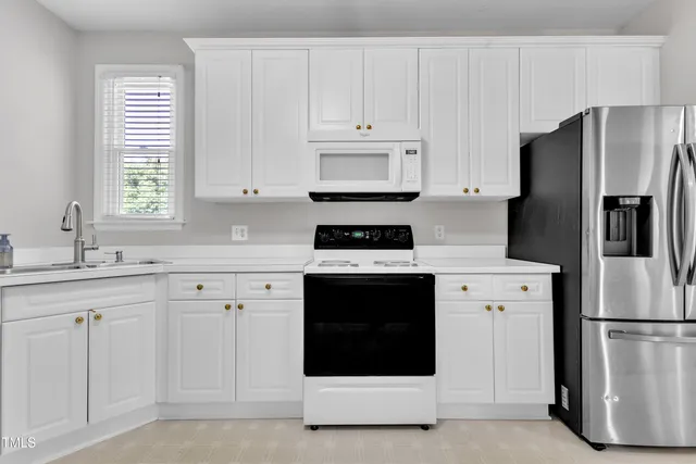 a kitchen with white cabinets and stainless steel appliances