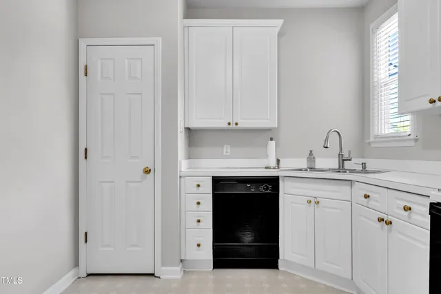 a kitchen with white cabinets and a sink