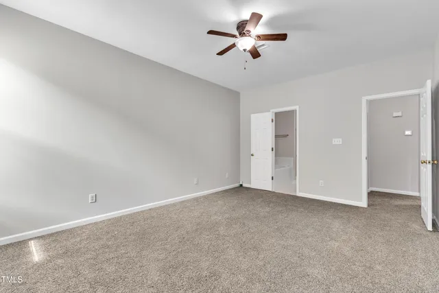 an empty room with chandelier fan and ceiling fan