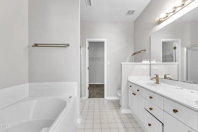 a bathroom with a tub sink and mirror
