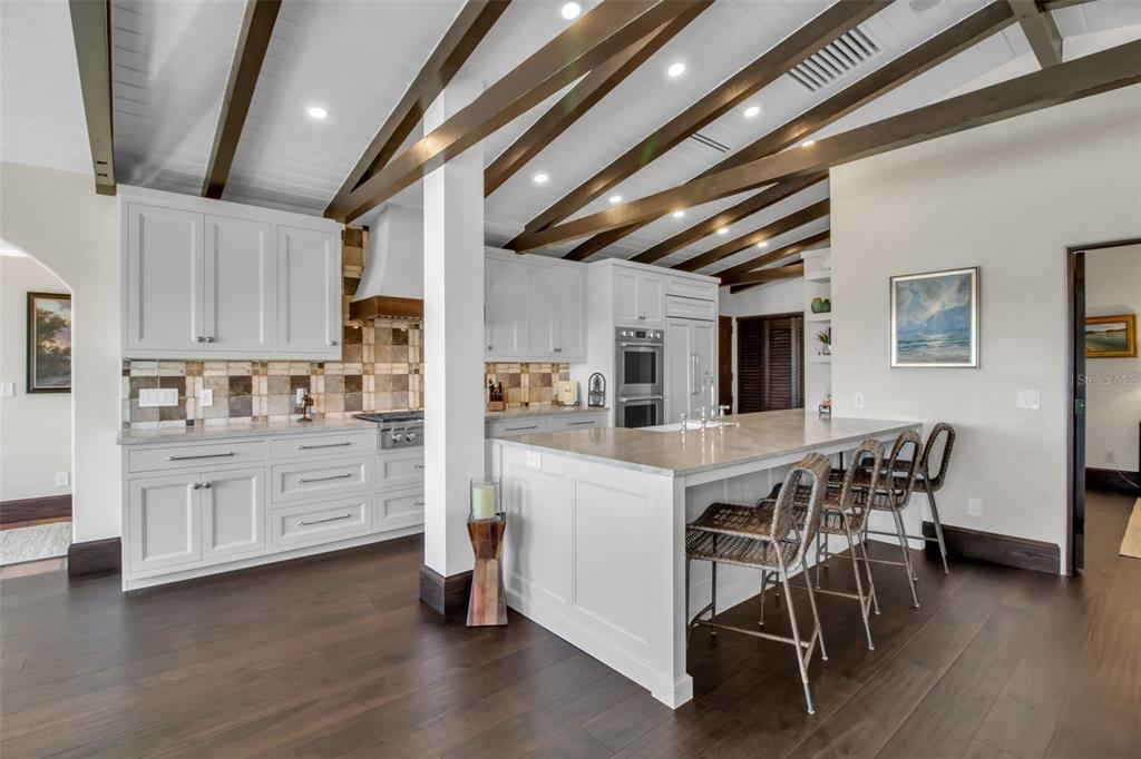 121 North Casey Key Road Osprey, FL 34229 - Photo 13 of 63 a kitchen with stainless steel appliances kitchen island granite countertop a table chairs sink and cabinets