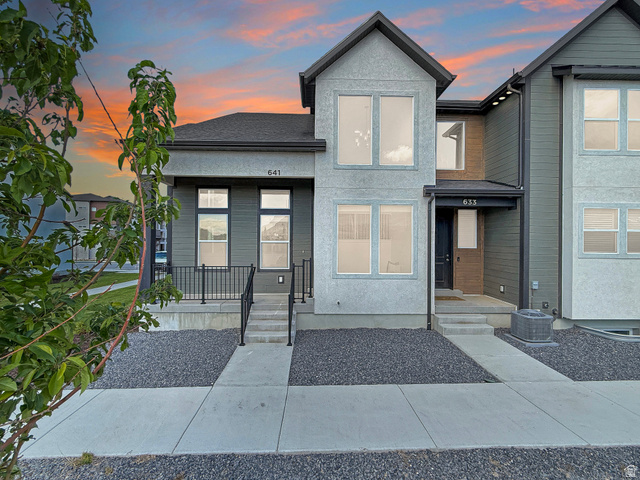 Contemporary home featuring a shingled roof and stucco siding