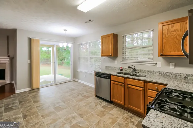 a spacious bathroom with stainless steel appliances granite countertop a sink and a bathtub