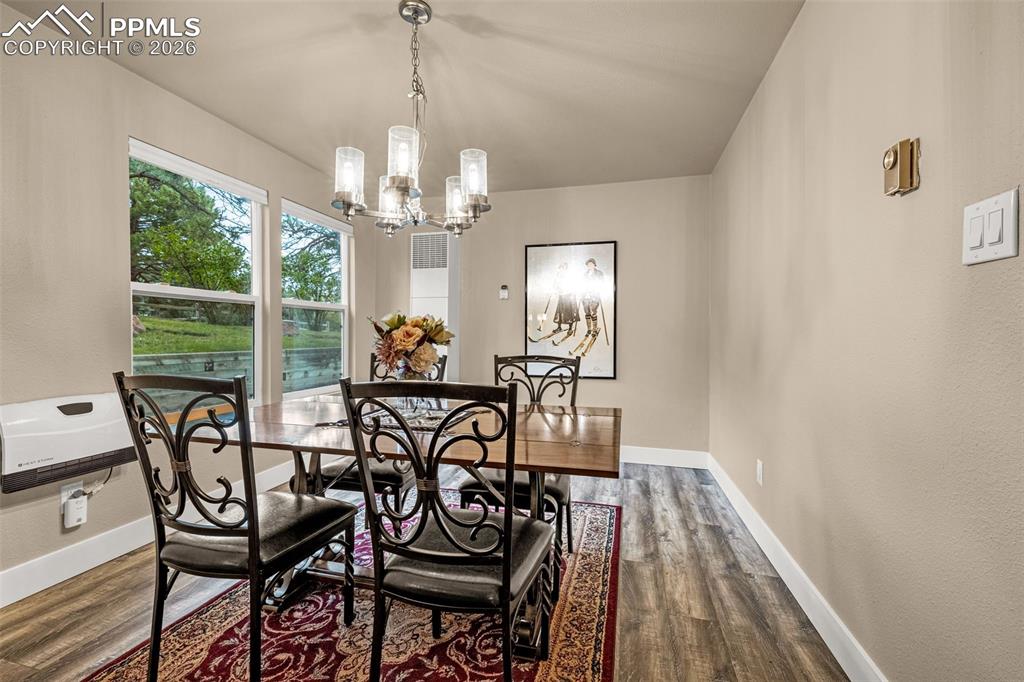 1679 Deer Creek Road Monument, CO 80132 - Photo 12 of 21 Dining room with wood finished floors and a chandelier