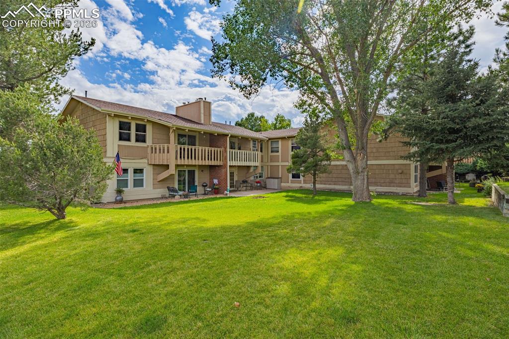 1679 Deer Creek Road Monument, CO 80132 - Photo 19 of 21 Rear view of property with a balcony, a chimney, and a yard