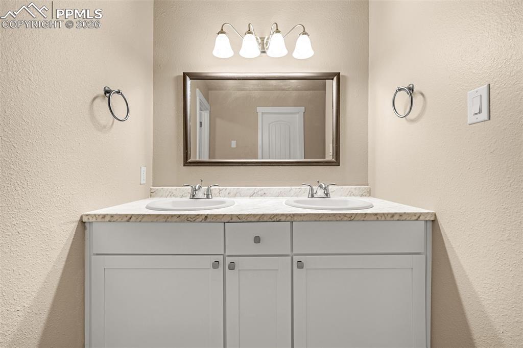 1679 Deer Creek Road Monument, CO 80132 - Photo 5 of 21 Bathroom with a textured wall and double vanity