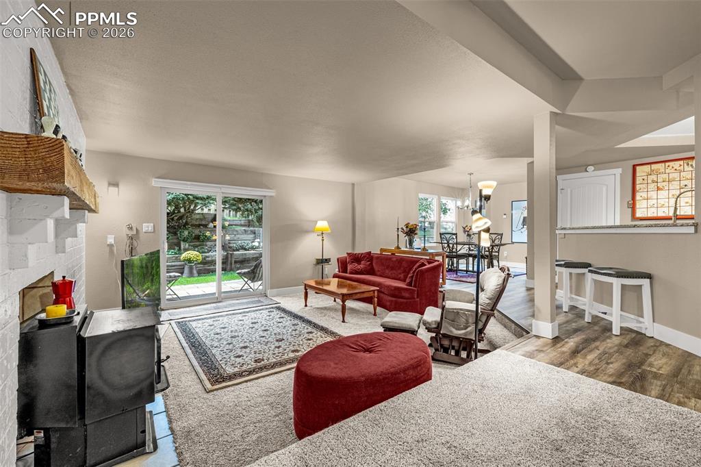 1679 Deer Creek Road Monument, CO 80132 - Photo 10 of 21 Living room with a fireplace, a chandelier, and wood finished floors