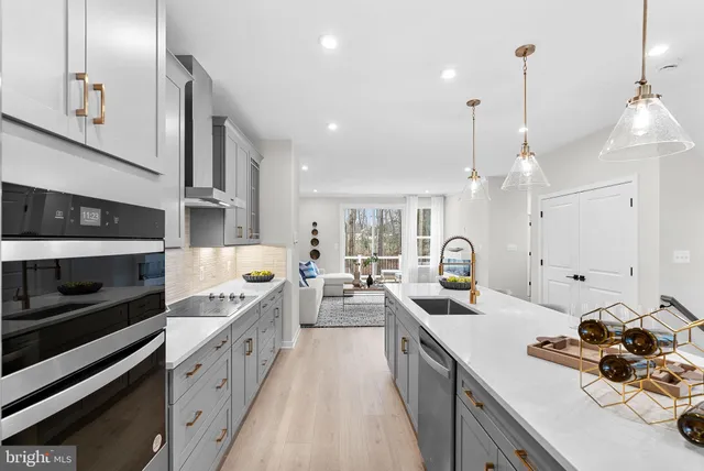 a kitchen with stainless steel appliances kitchen island a stove and a sink