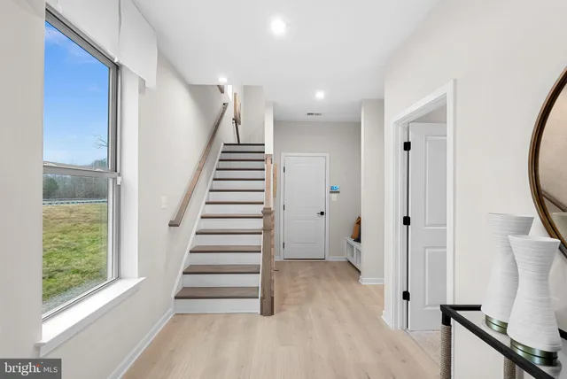 a view of entryway with wooden floor and stairs