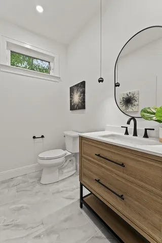 a bathroom with a toilet a sink and mirror