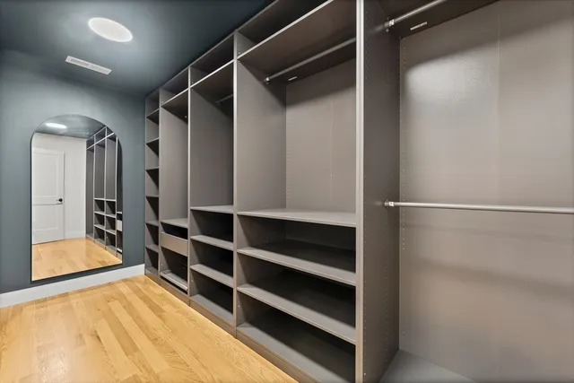 a view of walk in closet with empty racks