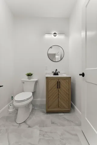 a bathroom with a toilet and a mirror