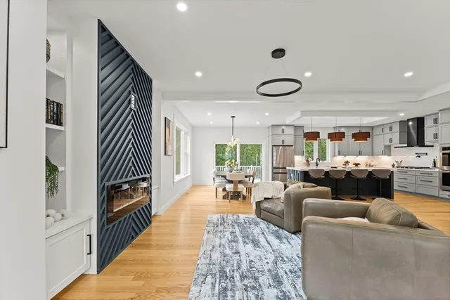 a living room with furniture kitchen view and a large window