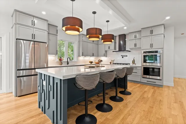 a kitchen with stainless steel appliances granite countertop a sink dishwasher a refrigerator with wooden floor and cabinets