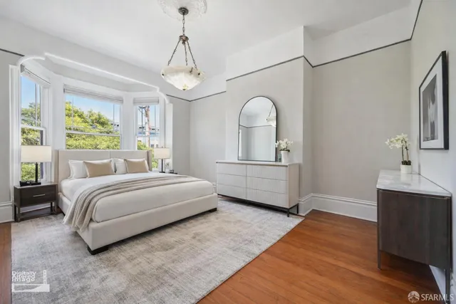 a view of a room with wooden floor exposed radiator and windows