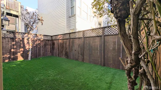 a view of a backyard with potted plants and wooden fence