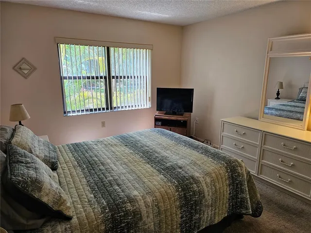 a bathroom with a granite countertop bathtub shower sink vanity and toilet