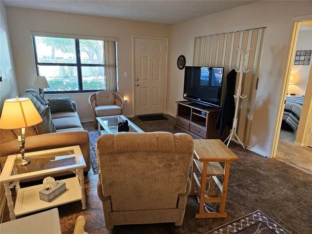 a living room with furniture a window and a flat screen tv