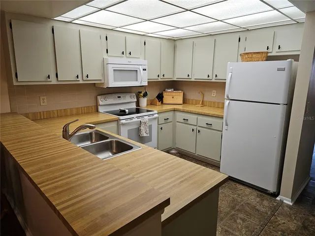 a kitchen with white cabinets and white appliances