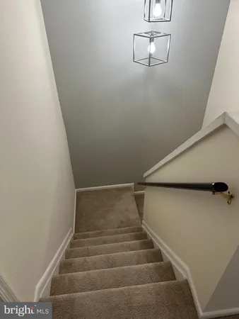 an empty room with windows and chandelier fan