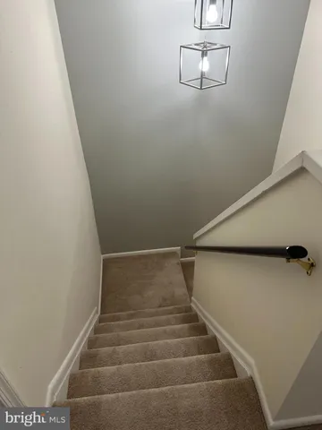 an empty room with windows and chandelier fan
