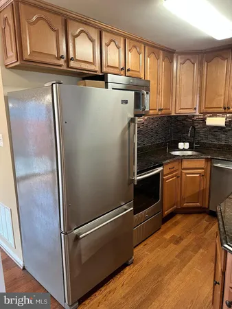 a kitchen with wooden cabinets and stainless steel appliances