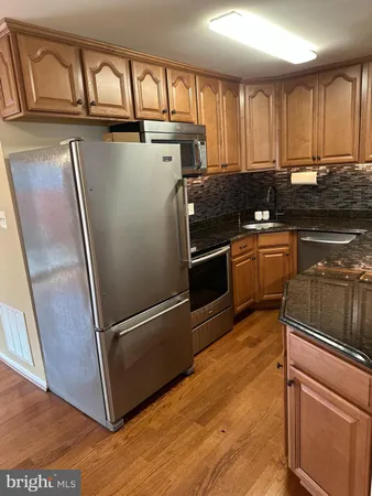 a kitchen with granite countertop a sink a stove and cabinets