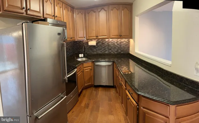 a kitchen with granite countertop a sink a stove and cabinets
