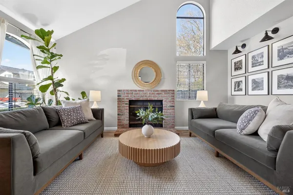 a living room with furniture a fireplace and a chandelier