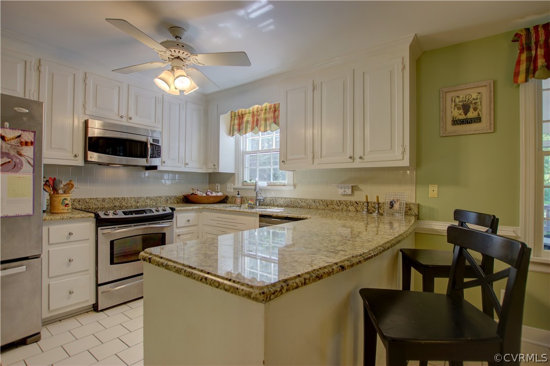 13711 Elmstead Road Midlothian, VA 23113 - Photo 14 of 47 a kitchen with a stove a sink a microwave and dining table