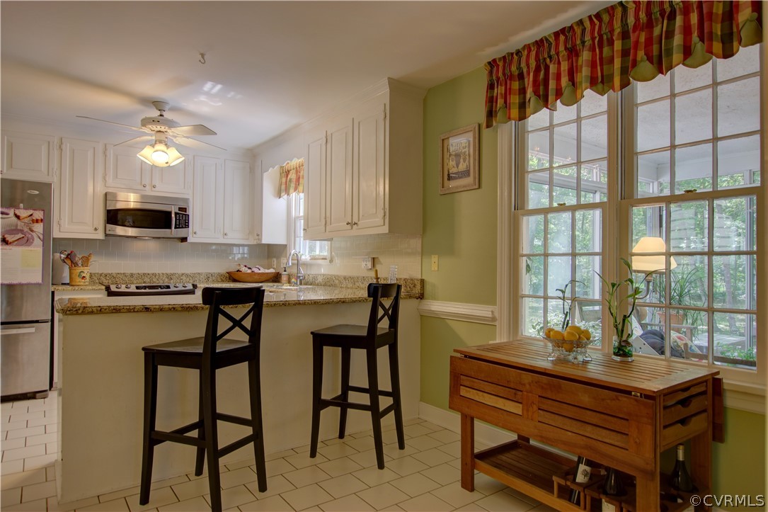 13711 Elmstead Road Midlothian, VA 23113 - Photo 17 of 47 a kitchen with kitchen island granite countertop a table chairs sink and cabinets