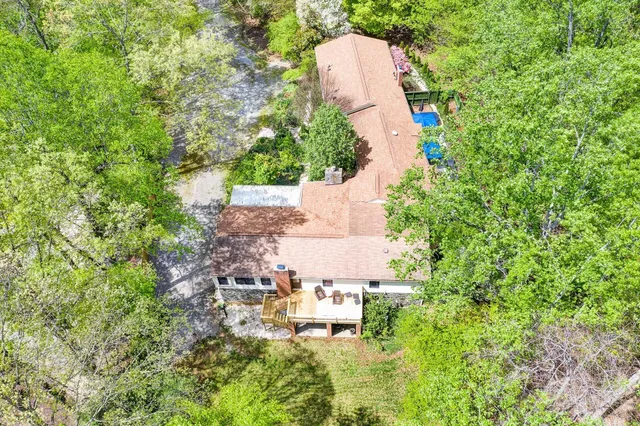 a aerial view of a house with a yard and trees
