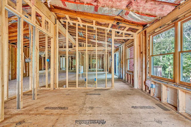 a large kitchen with stainless steel appliances granite countertop a refrigerator a stove top oven a sink dishwasher and white cabinets with wooden floor