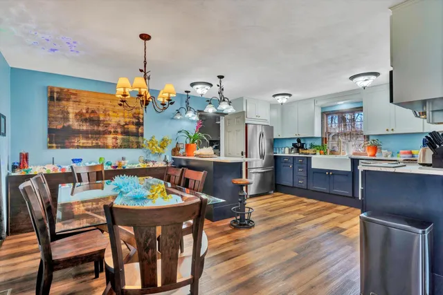 a kitchen with stainless steel appliances a stove cabinets and a dining table