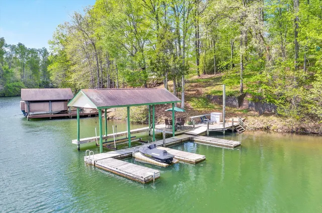 a view of a patio with couches table and chairs under an umbrella