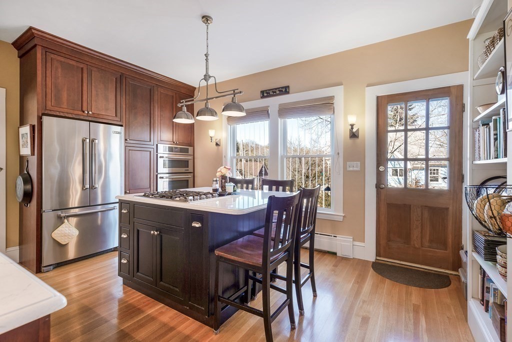 2 Clifton Park Melrose, MA 02176 - Photo 16 of 28 a kitchen with stainless steel appliances granite countertop a refrigerator a stove a sink dishwasher a dining table and chairs with wooden floor